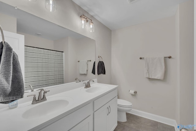 bathroom featuring vanity, tile patterned flooring, toilet, and walk in shower