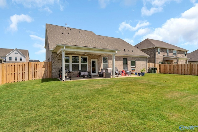 back of house with a patio area and a lawn