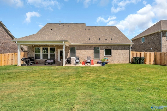 rear view of property featuring a lawn and a patio area