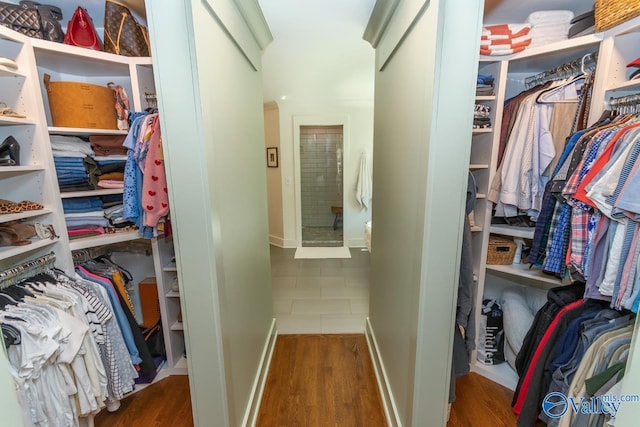 walk in closet with dark hardwood / wood-style floors