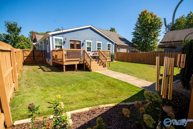 back of property with a wooden deck and a yard