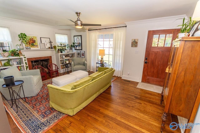 living room featuring wood-type flooring, ceiling fan, and ornamental molding