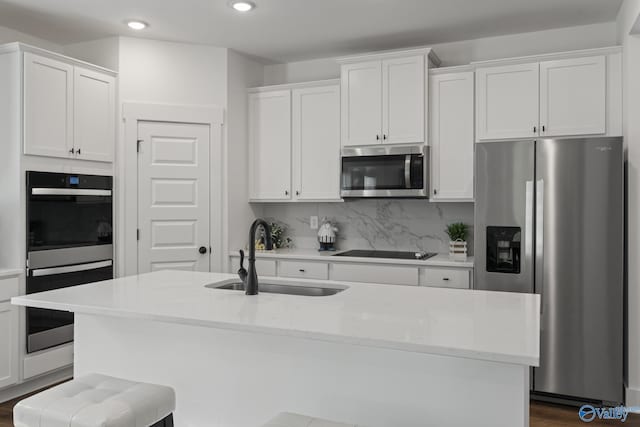 24139 Patriot Dr, Athens, AL 35613 - kitchen featuring sink, appliances with stainless steel finishes, a kitchen island with sink, white cabinets, and decorative backsplash