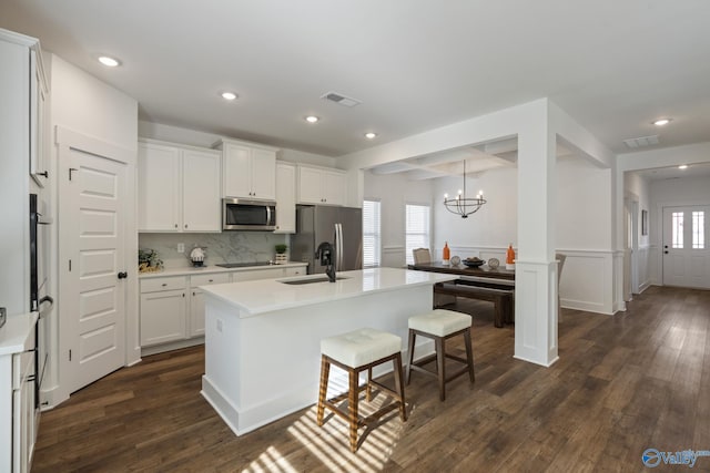 24139 Patriot Dr, Athens, AL 35613 - kitchen featuring white cabinetry, decorative light fixtures, dark hardwood / wood-style floors, stainless steel appliances, and a kitchen island with sink