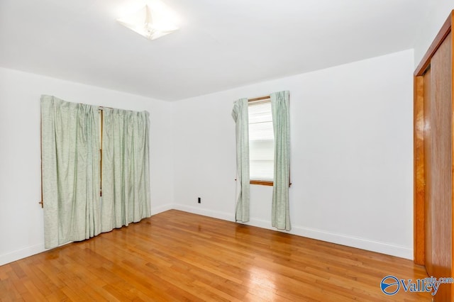 spare room featuring light wood-style flooring and baseboards