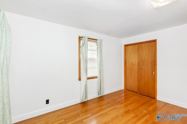 unfurnished bedroom with light wood-type flooring and baseboards