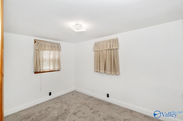 carpeted spare room featuring baseboards