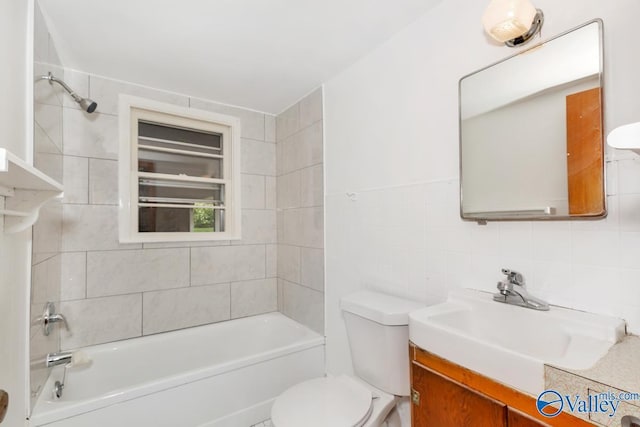 bathroom with vanity, tile walls, and toilet