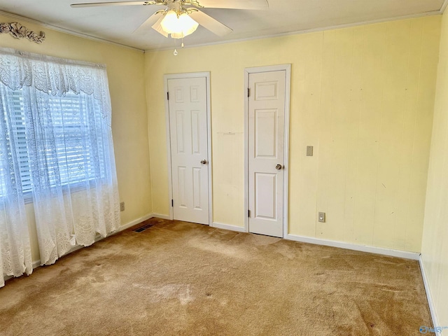 unfurnished bedroom featuring crown molding, ceiling fan, and carpet flooring