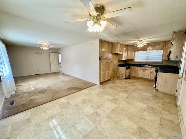 kitchen with ceiling fan, sink, range, and light brown cabinetry