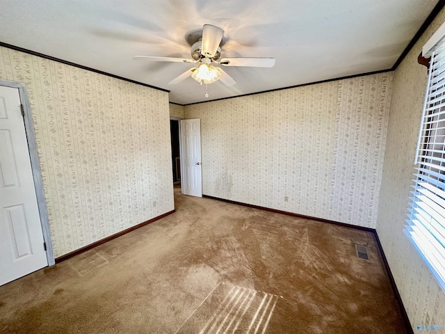 unfurnished bedroom with ornamental molding, carpet, and ceiling fan