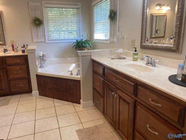 bathroom featuring tile patterned floors, a healthy amount of sunlight, a bath, and vanity