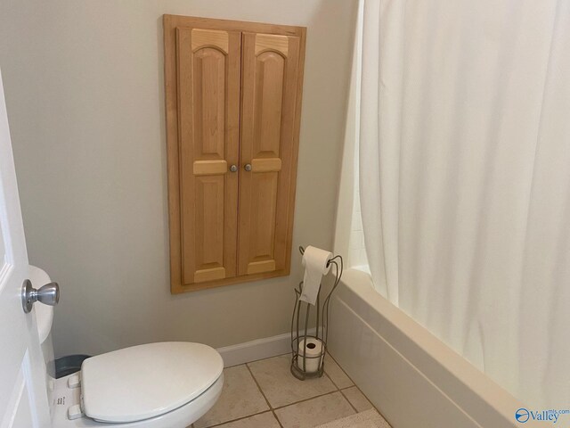 bathroom featuring tile patterned flooring, toilet, and shower / tub combo