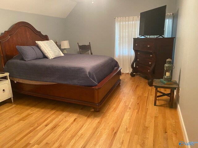 bedroom featuring vaulted ceiling and light hardwood / wood-style flooring