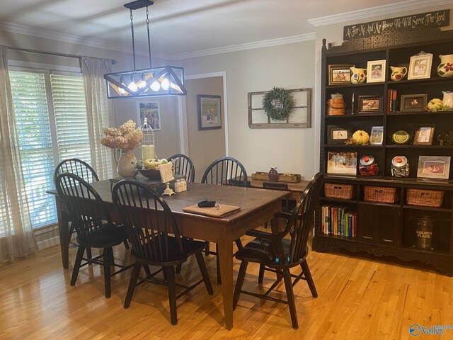 dining area with light hardwood / wood-style flooring and ornamental molding