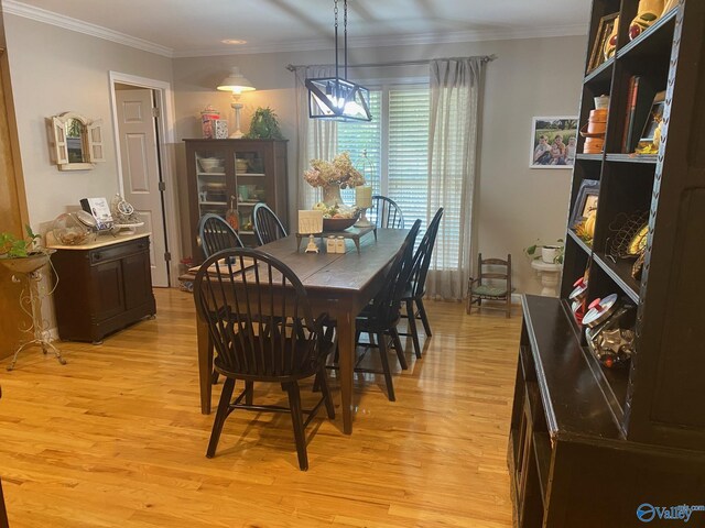 dining space featuring crown molding and light wood-type flooring