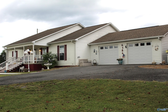 single story home with a porch, a garage, and a front yard