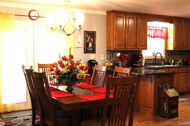 dining room featuring a notable chandelier, ornamental molding, and hardwood / wood-style floors