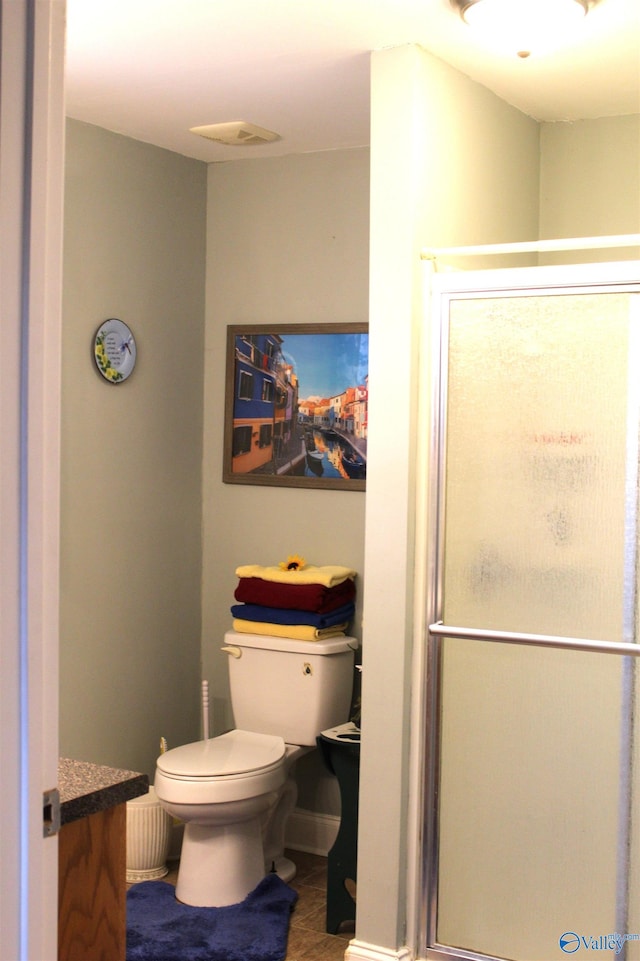 bathroom with walk in shower, vanity, and toilet