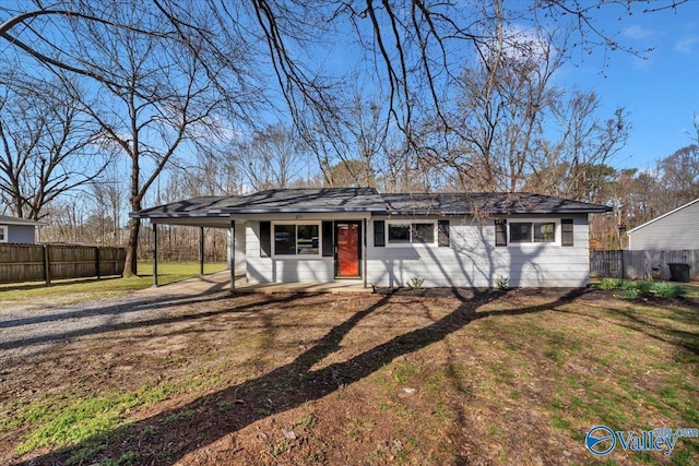 view of front of home with an attached carport, a front yard, and fence