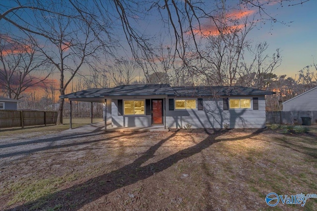 view of front facade with dirt driveway, fence, and a yard