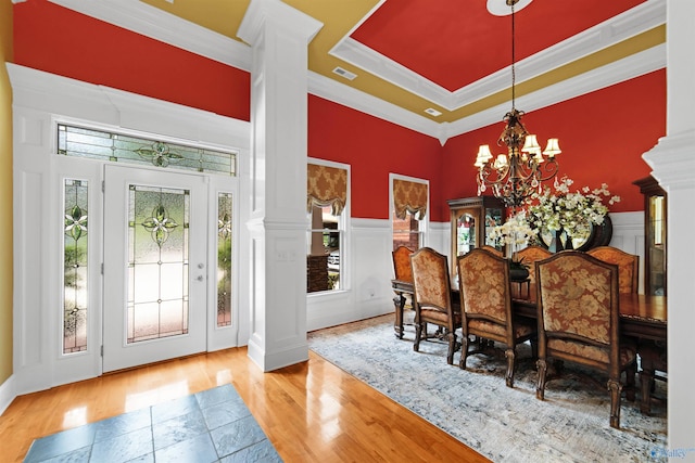 601 Smokey Mountain Cir, Huntsville, AL 35803 - dining area featuring wood finished floors, a chandelier, ornate columns, a decorative wall, and a wainscoted wall