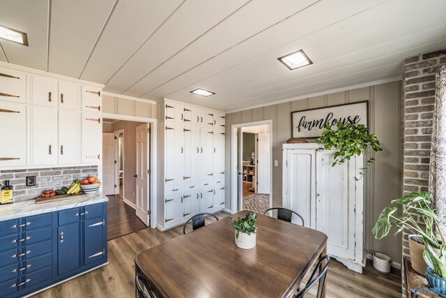 dining space featuring dark wood-type flooring and ornamental molding