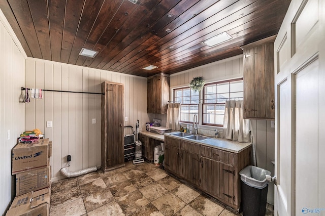 kitchen with dark brown cabinetry, sink, and wooden ceiling