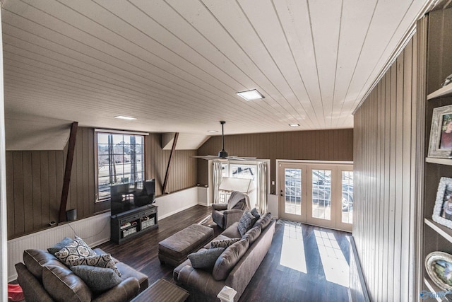 living room with dark hardwood / wood-style floors, vaulted ceiling, and wood walls