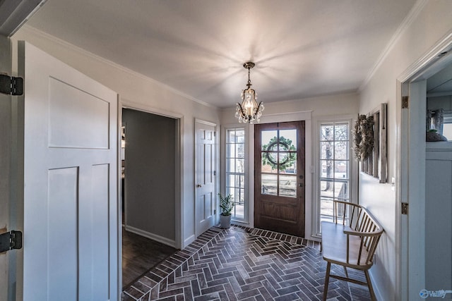 entryway featuring ornamental molding and a chandelier