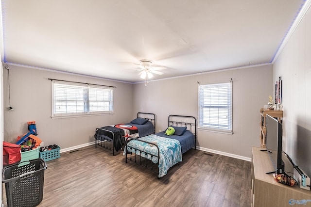 bedroom featuring hardwood / wood-style flooring, ornamental molding, ceiling fan, and multiple windows