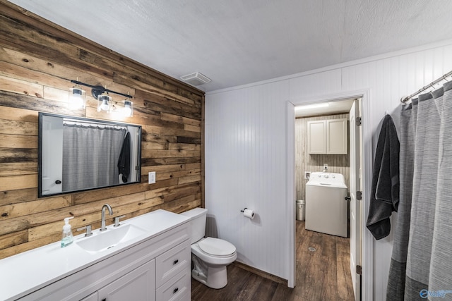 bathroom with toilet, a shower with curtain, vanity, washer / clothes dryer, and hardwood / wood-style floors