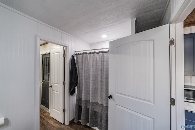 bathroom featuring a shower with curtain, ornamental molding, wood-type flooring, and a textured ceiling