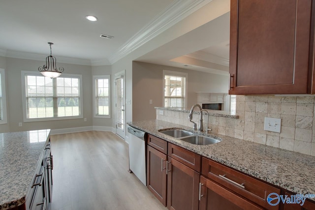 kitchen with light stone counters, stainless steel dishwasher, ornamental molding, and sink