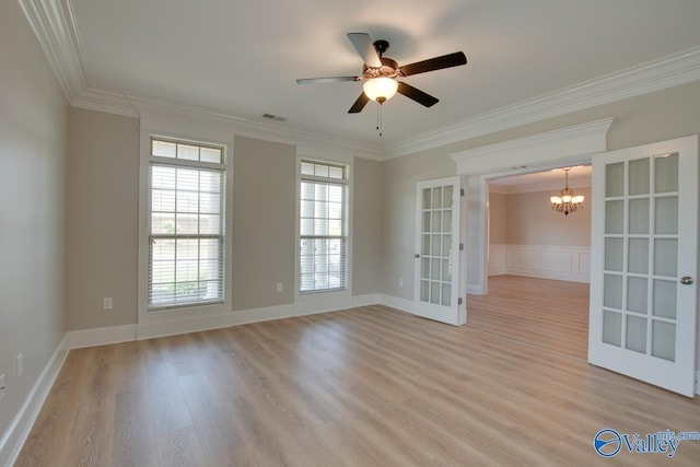 empty room with crown molding, light hardwood / wood-style floors, and french doors