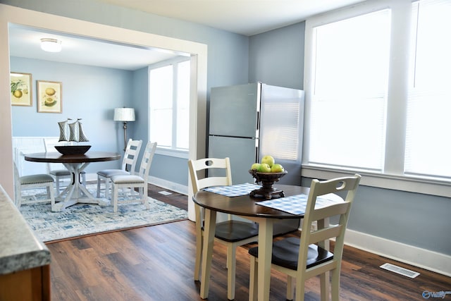 dining area featuring dark wood-type flooring and a wealth of natural light