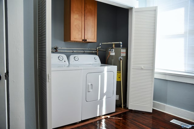 laundry area featuring cabinets, dark hardwood / wood-style floors, gas water heater, and separate washer and dryer