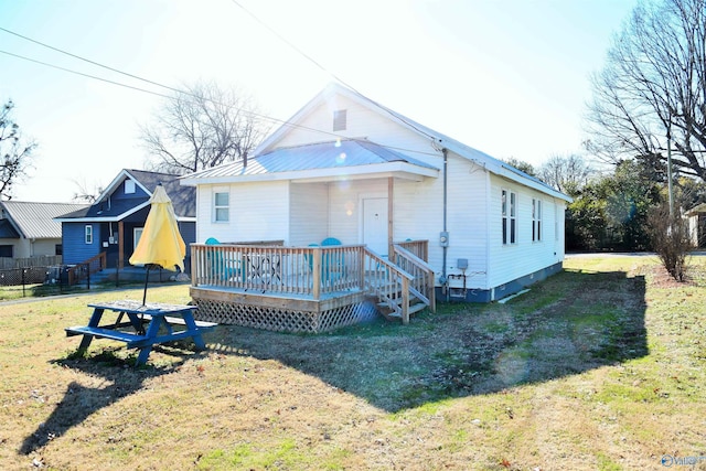 back of property with a lawn and a wooden deck