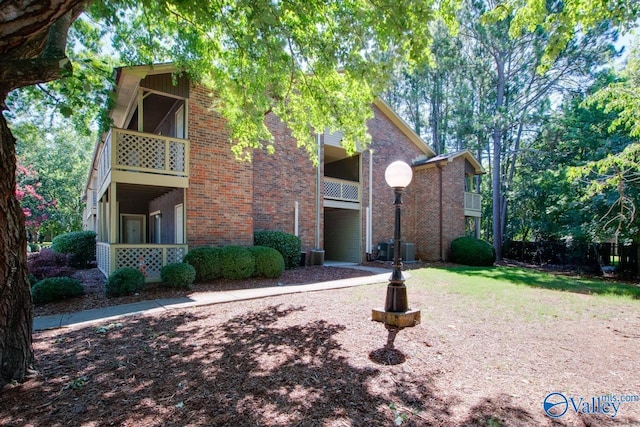 exterior space with a balcony and brick siding