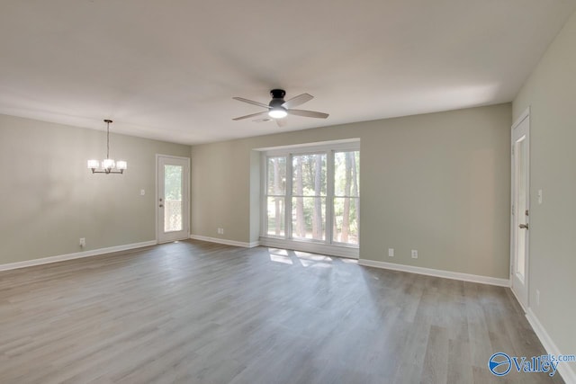 spare room with light hardwood / wood-style floors and ceiling fan with notable chandelier