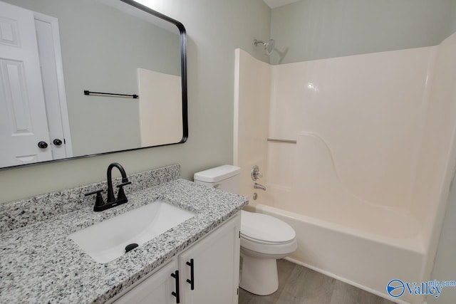 full bathroom featuring toilet, wood-type flooring, shower / washtub combination, and vanity