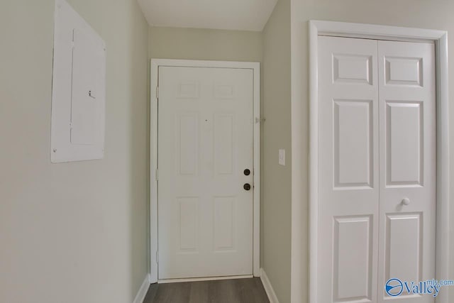 doorway featuring dark wood-style flooring, electric panel, and baseboards