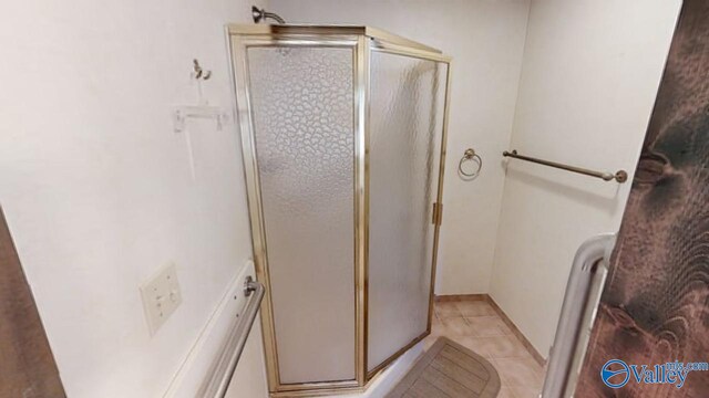 bathroom with a shower with shower door and tile patterned floors