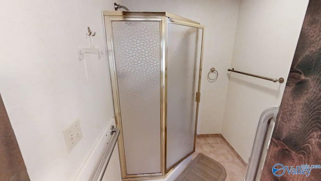 bathroom with a shower with door and tile patterned floors