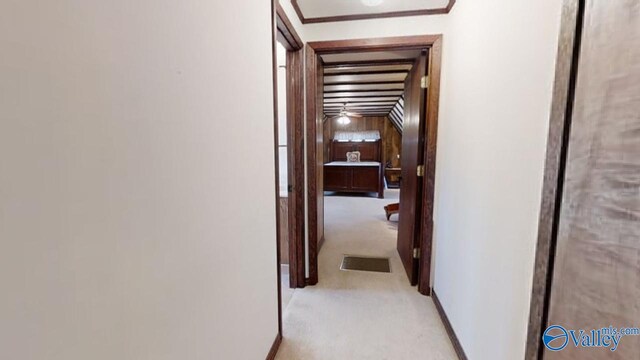 hallway featuring light colored carpet and wooden walls