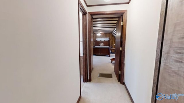 corridor featuring crown molding and light colored carpet