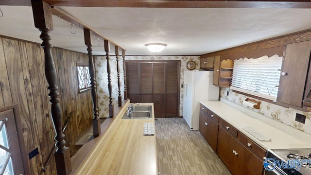 kitchen with sink, white appliances, and light wood-type flooring