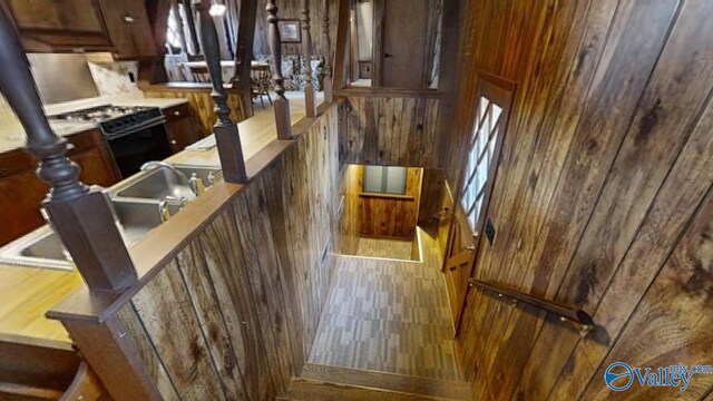 staircase with hardwood / wood-style flooring and wooden walls