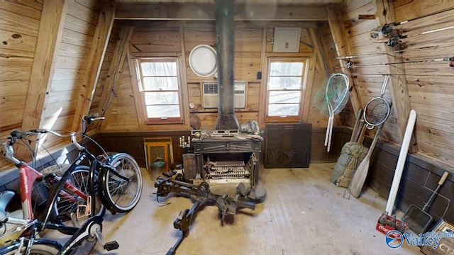 interior space featuring plenty of natural light, a wood stove, and wood walls