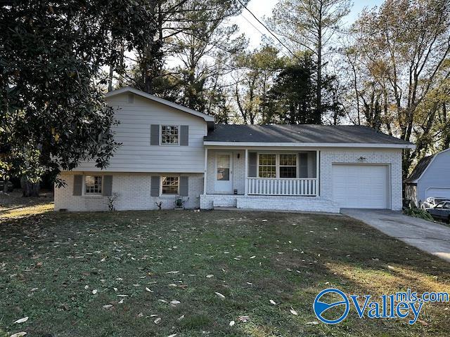 split level home featuring covered porch, a garage, and a front lawn